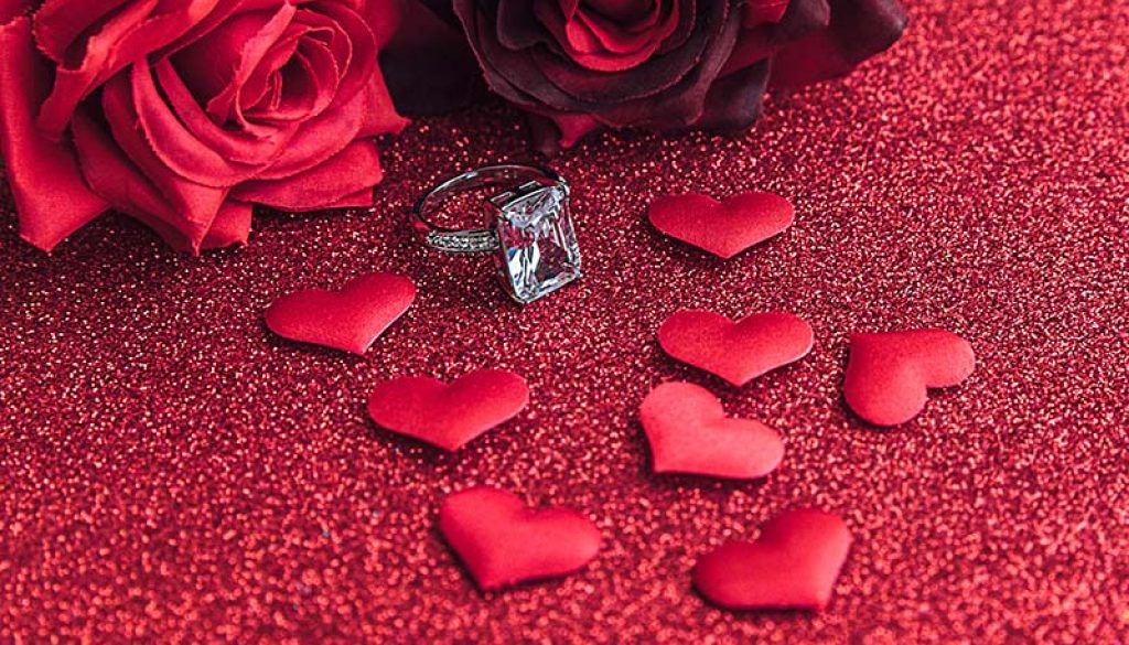 Will you marry me. Wedding ring red scarlet roses and many red hearts on red glitter background. Engagement marriage proposal wedding concept. St. Valentine's Day postcard. Banner on valentines day.