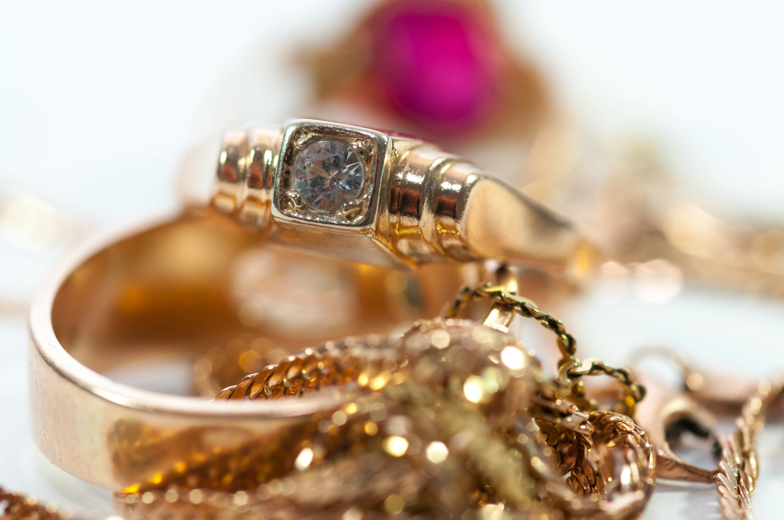 Gold jewelry with gems , chains close up macro shot isolated on white background.